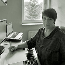 Frau mit Stift an einem Schreibtisch