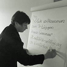 Frau mit Stift schreibend an einem Whiteboard